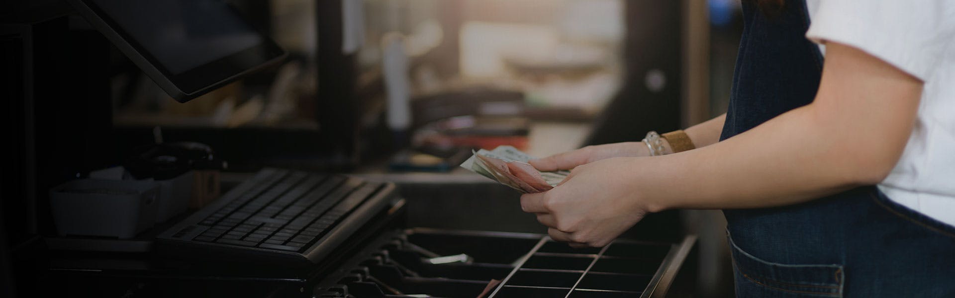 Image of hands counting cash from the cash register.