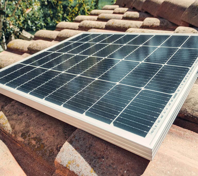 A close-up of a solar panel on a roof at a slight angle to attract the most sunlight.