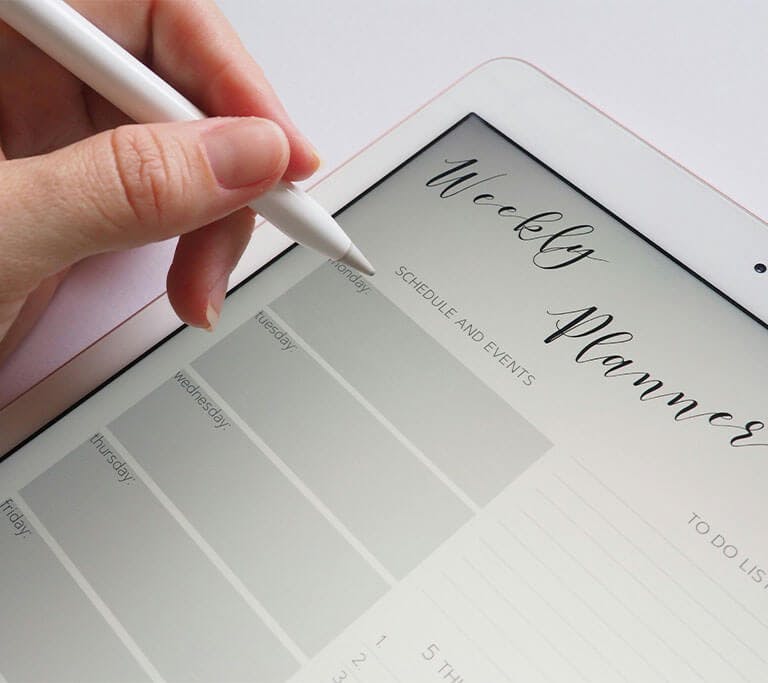 A person holding a white stylus plans out their schedule on their tablet, which displays a blank weekly planner and to-do list.