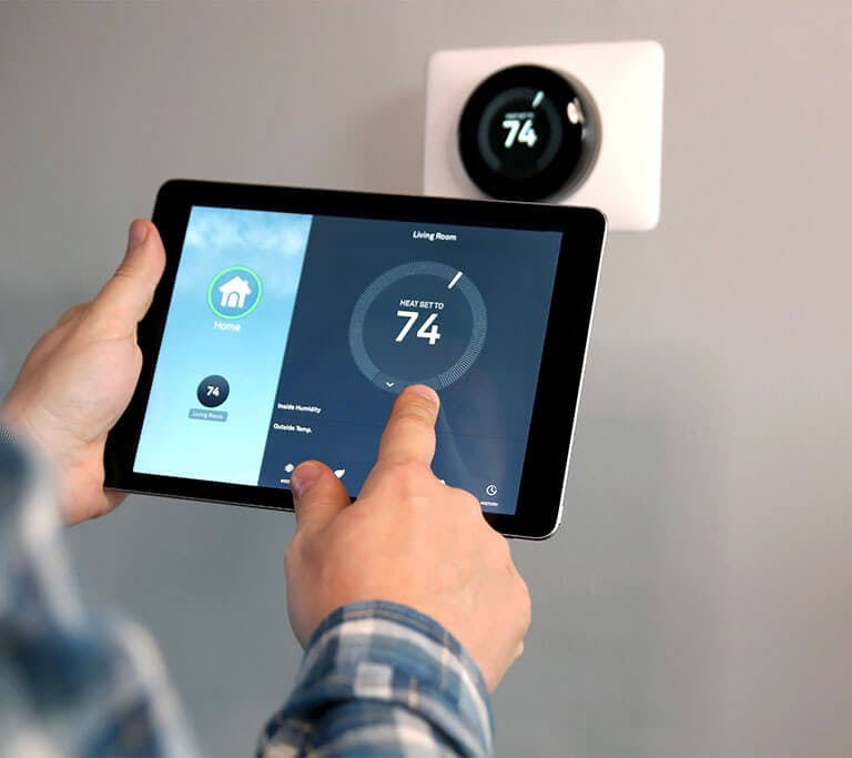 Man is Adjusting a temperature using a tablet with smart home app in modern living room