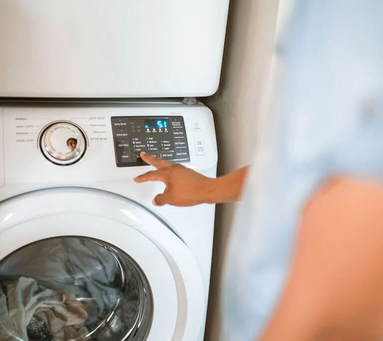 Someone using a front-load washing machine.