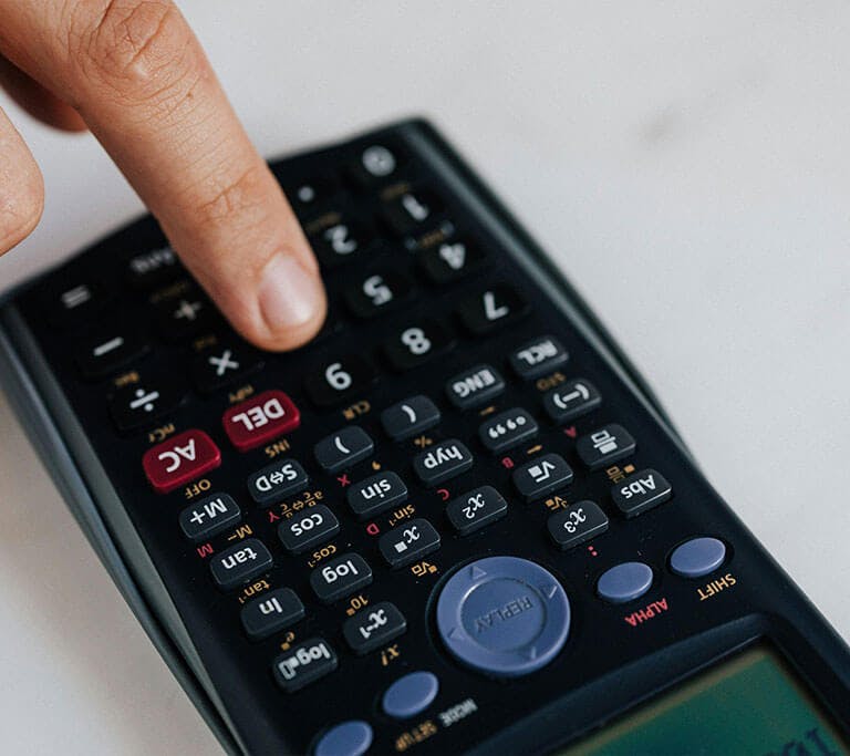 A close-up of a person pressing a button on a calculator.