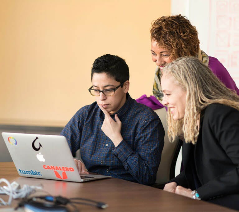 A group of employees look over a computer presentation.