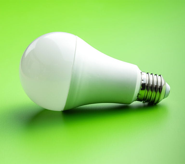 LED light bulb on green background