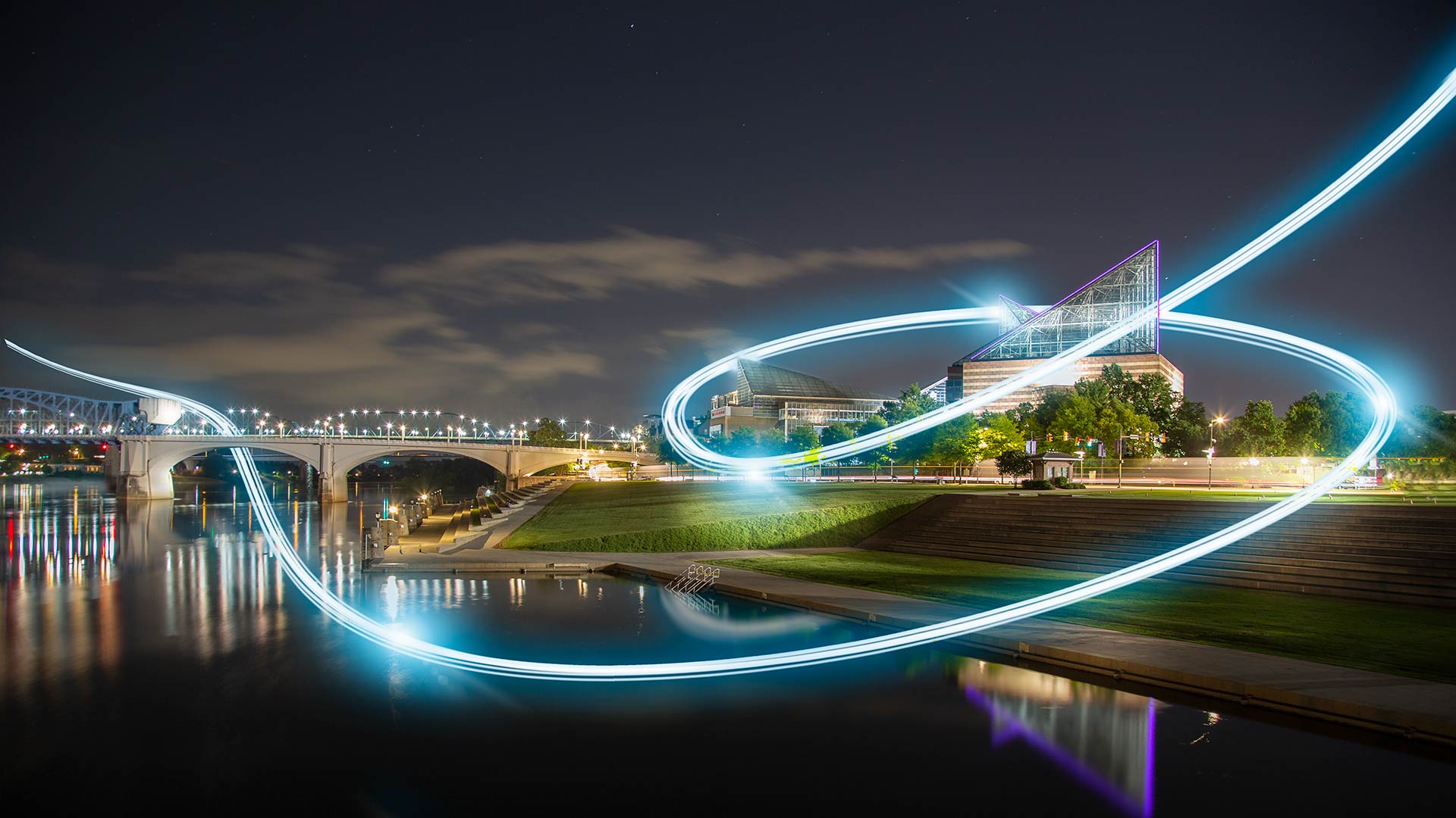 View of the Tennessee Aquarium at night from across the river with fiber light streaks in sky