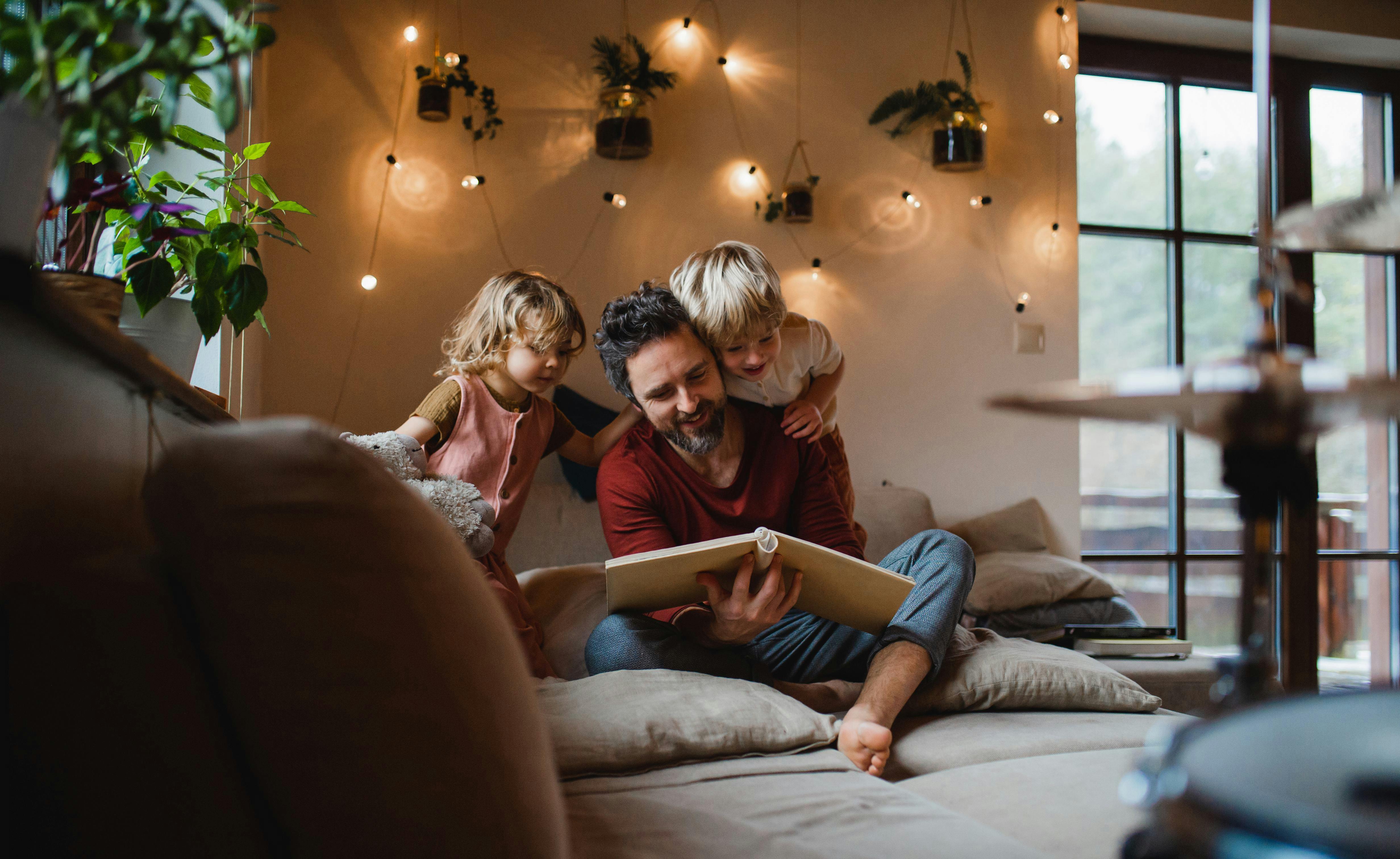 father-and-children-reading-a-book-together-at-.original.jpg