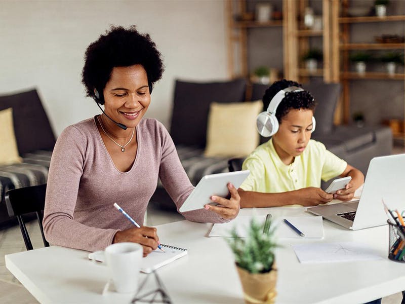 Mom working from home while child streams video on phone