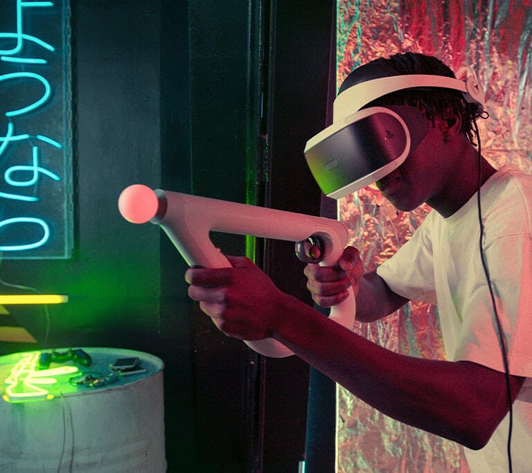 A person wearing a virtual reality headset plays an immersive VR game using a motion controller shaped like a gun. They are in a neon-lit room with colorful lighting, metallic walls and a glowing Japanese sign in the background.