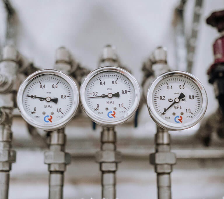 Three pressure gauges with various readings.