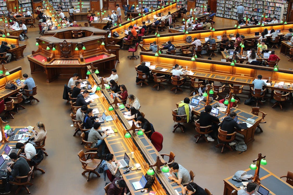 Dozens of students use their computers at a college library while connected to many different Wi–Fi networks.