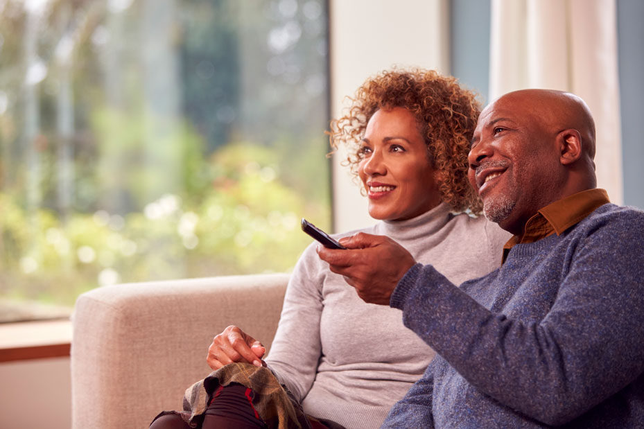 senior-couple-sitting-on-sofa-at-home-watching-tv-2024-10-19-13-46-11-utc.jpg