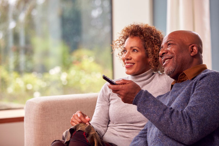 senior-couple-sitting-on-sofa-at-home-watching-tv-2024-10-19-13-46-11-utc.jpg